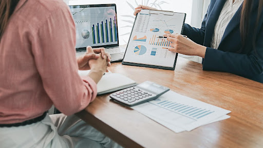 Two professionals review charts and financial data at a desk, symbolizing the pursuit of building a business with purpose and long-term impact.