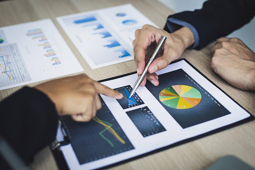 Two professionals analyzing financial charts and graphs to understand how home care services generate revenue and ensure sustainable care business growth.