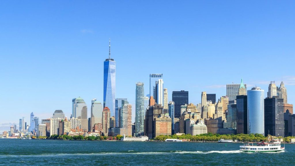 Scenic view of New York City skyline with a boat sailing in the foreground—one of the top cities in the US to launch a home care business.