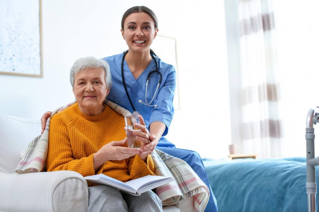 Smiling caregiver supporting an elderly woman at home, symbolizing how compassionate senior care can grow into a lasting legacy business through a purposeful franchise.