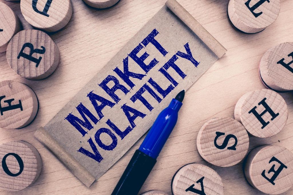 Concept image showing the words ‘Market Volatility’ on a paper scroll with wooden letter blocks and a blue marker, symbolizing challenges of buying a franchise in a saturated market.