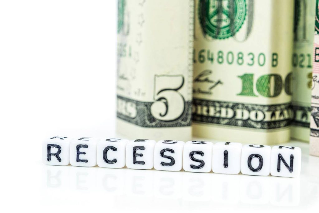 Recession concept with dollar bills and blocks, representing why investing in an Ace Home Care Franchise can be a stable opportunity during a recession.