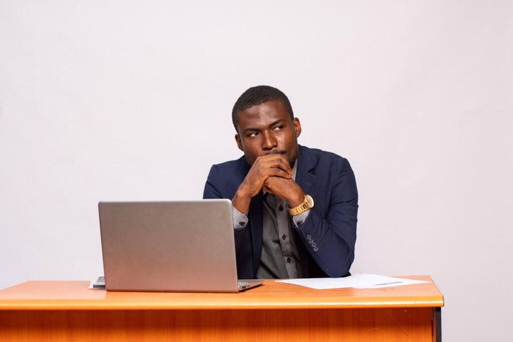 Entrepreneur thoughtfully planning to Own a business while working on a laptop, representing leadership readiness with Ace Home Care Franchise opportunity in the growing home care industry.