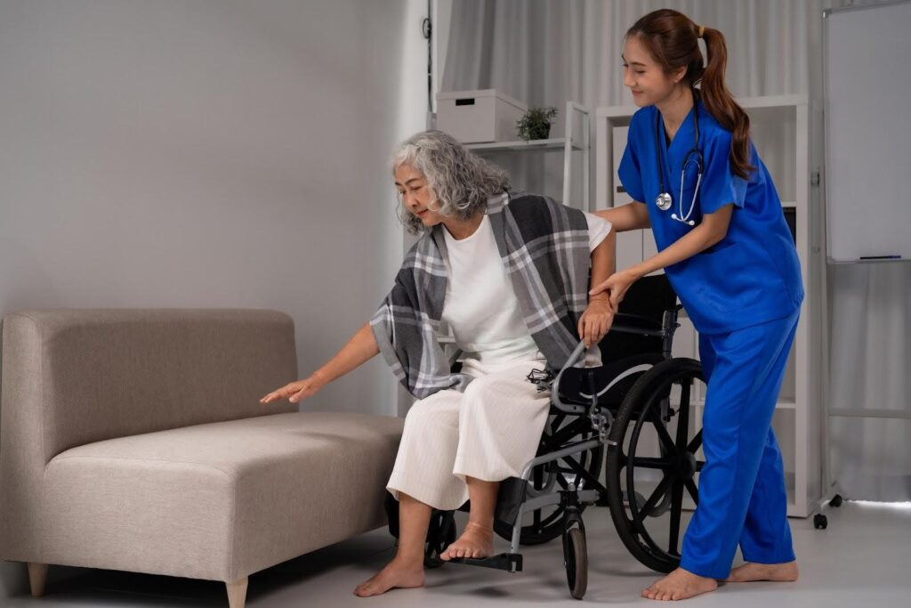 Ace Home Care Franchise caregiver assisting a senior safely transferring from a wheelchair, illustrating how franchising helps manage regulatory compliance and operational standards in home care.