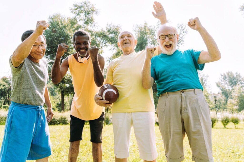 Active seniors celebrating outdoors, illustrating the stable Economics of aging population demand supported by Ace Home Care Franchise senior care services.