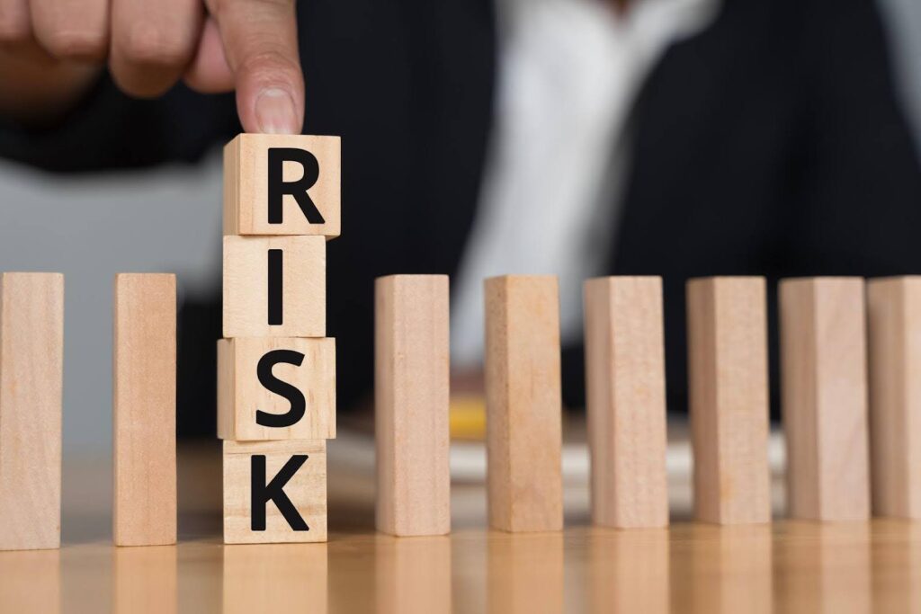 Wooden blocks spelling Risk being stacked to represent business planning and startup protection, illustrating how Ace Home Care Franchise systems help reduce Risk for new franchise owners.
