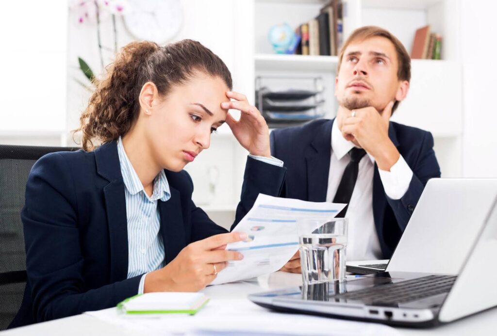 Business owners reviewing documents and discussing operational challenges, illustrating how Ace Home Care Franchise support helps reduce common Mistakes for new franchise operators.