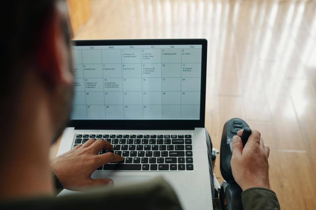 Care coordinator managing scheduling on laptop showing challenges in home care operations at Ace Home Care Franchise