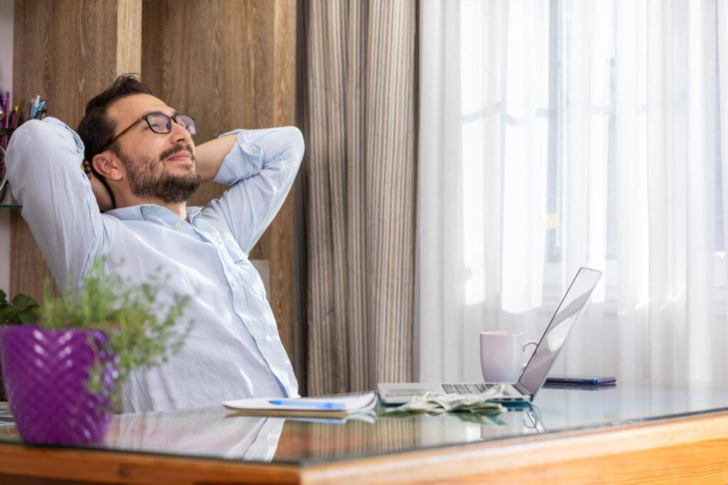 Business owner relaxing at desk while learning the truth about easy business ownership with Ace Home Care Franchise