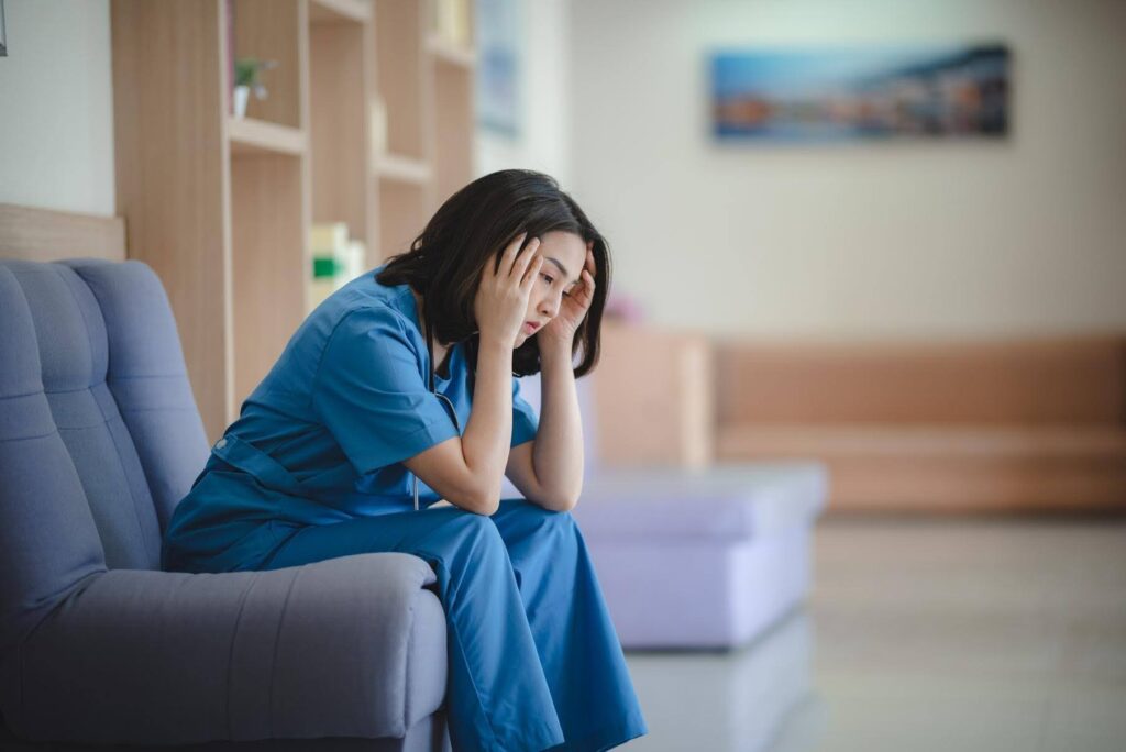 Burned-out nurse reflecting on career growth opportunities through Ace Home Care Franchise, where healthcare professionals transition from caregiving roles to business ownership
