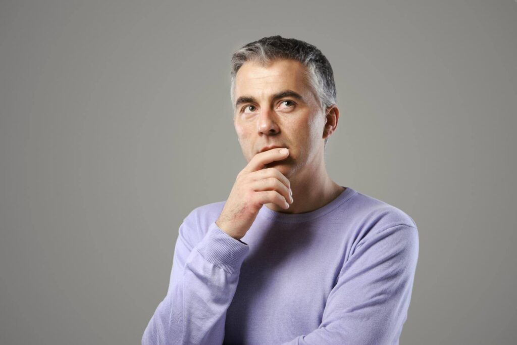 Thoughtful entrepreneur considering whether to buy an Ace Home Care Franchise after evaluating key questions about business ownership and long-term goals