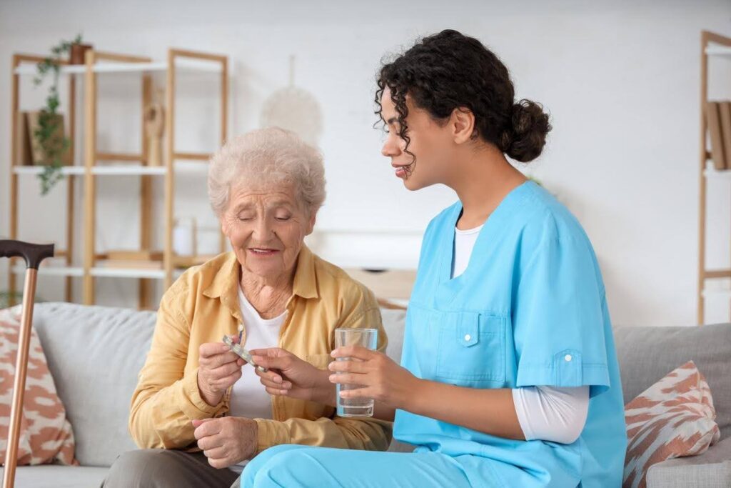 Caregiver assisting an older adult with medication at home, illustrating the difference between medical and non-medical home care services offered through an Ace Home Care Franchise.