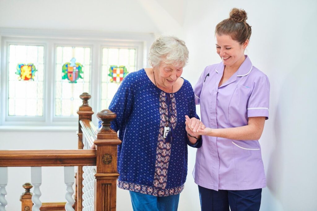 Caregiver assisting a senior with safe mobility at home, illustrating why Ace Home Care Franchise is a recession-proof home care business opportunity