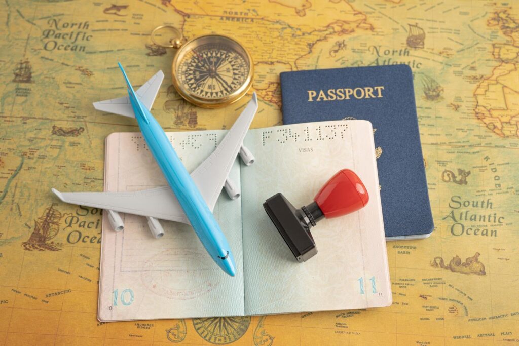Passport, visa documents, and travel essentials representing the E-2 visa process for entrepreneurs pursuing a purpose-driven business with Ace Home Care Franchise in the senior care industry.