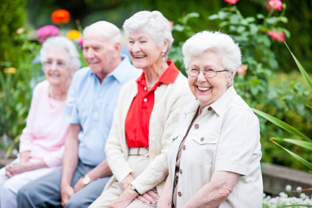 Smiling older adults enjoying time together outdoors, representing the aging population driving demand for Ace Home Care Franchise senior care services